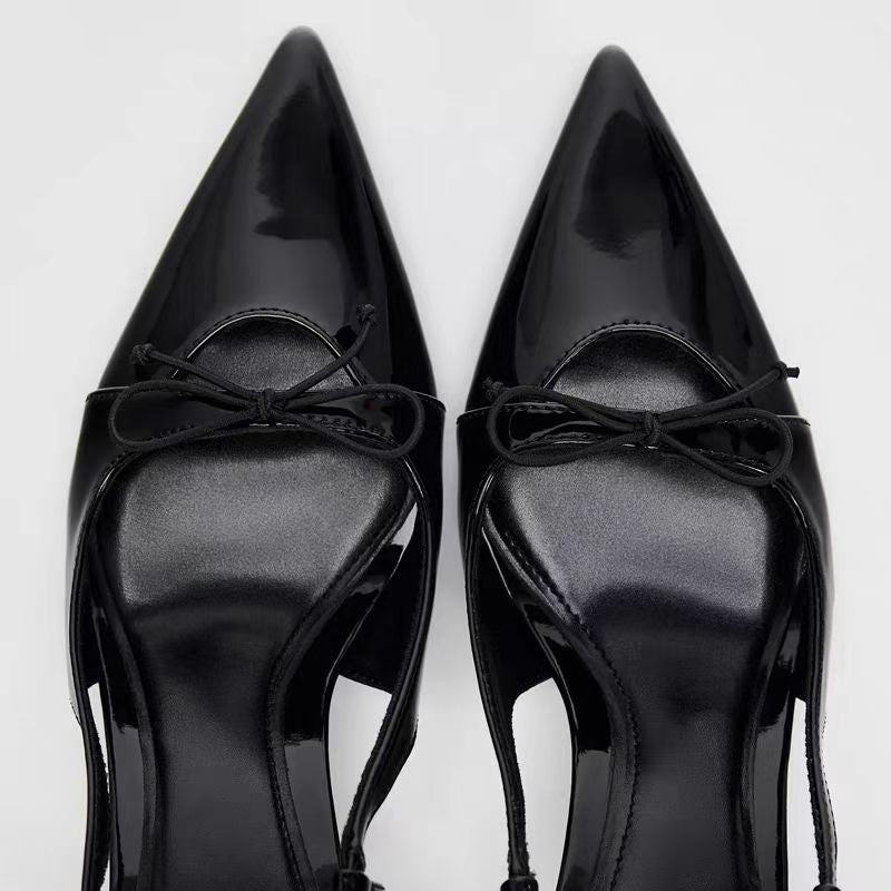 Patent leather bow with pointed tip thin heel and a shallow strap sandals