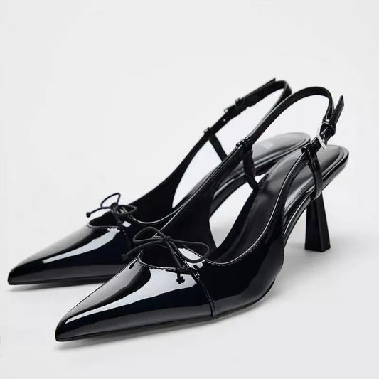 Patent leather bow with pointed tip thin heel and a shallow strap sandals